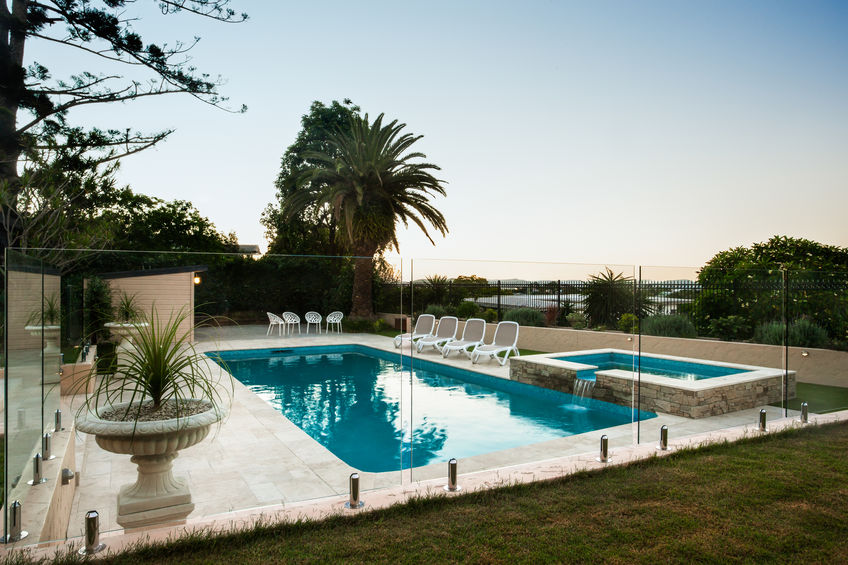 nicely decorated swimming pool with a garden and flowering pot